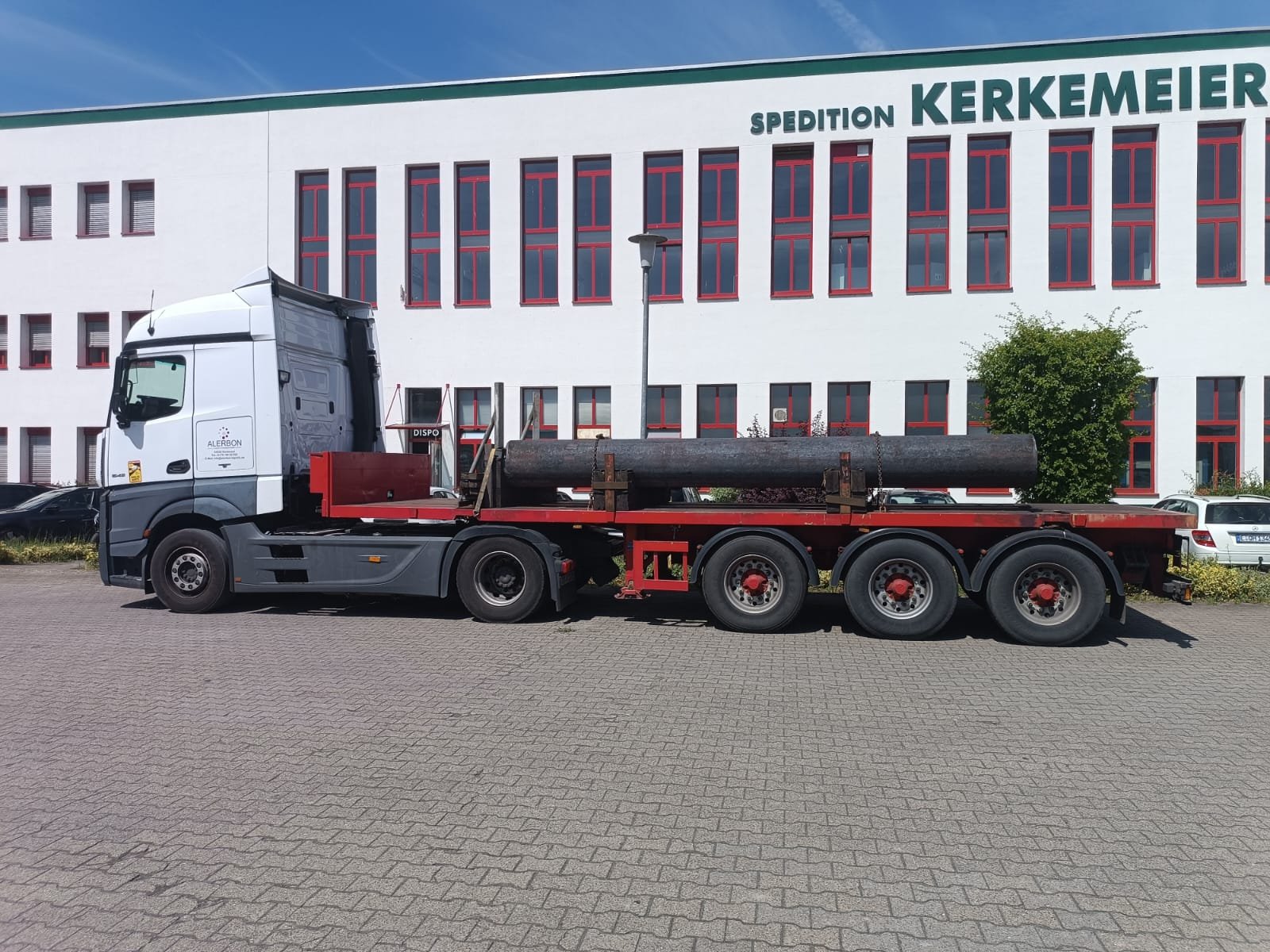 ALERBON Sattelzug mit Plateauauflieger und Rohrladung im Profil